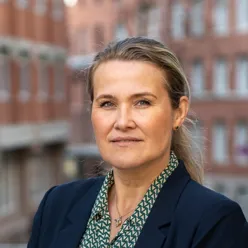 En kvinne som smiler til kameraet