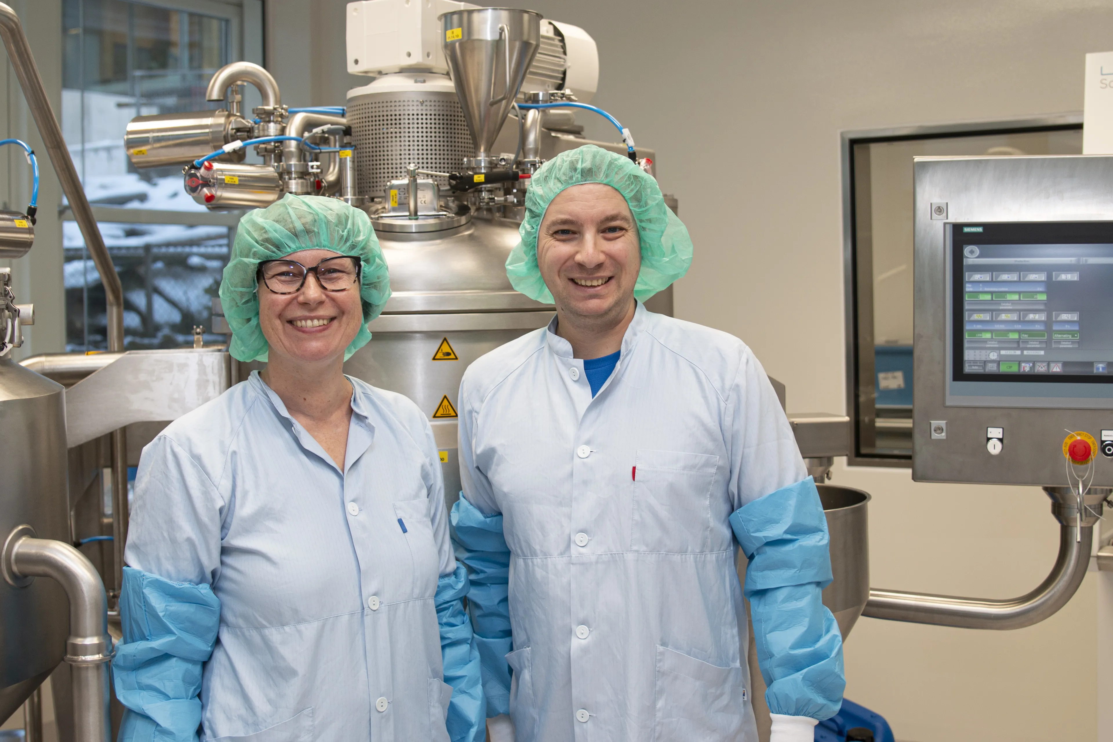 Et par personer iført kirurgiske skrubber og masker